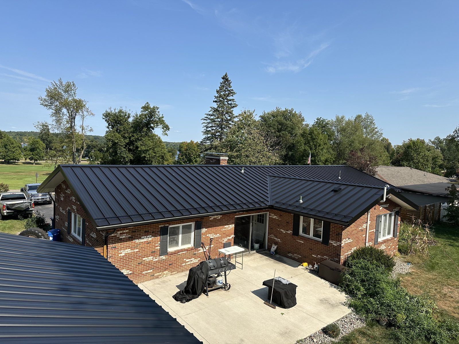 Black standing seam metal roof on a brick ranch home