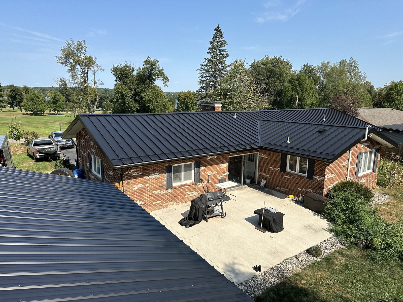 Exposed fastener metal roof on a brick home