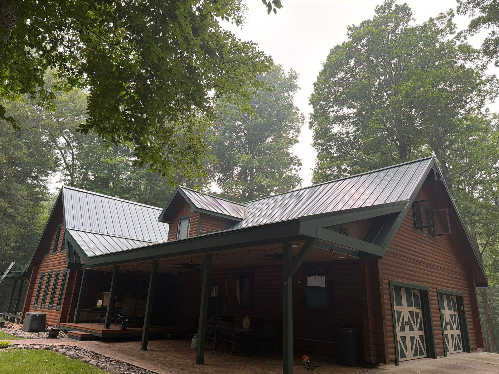 Gray standing seam metal roof on a log home